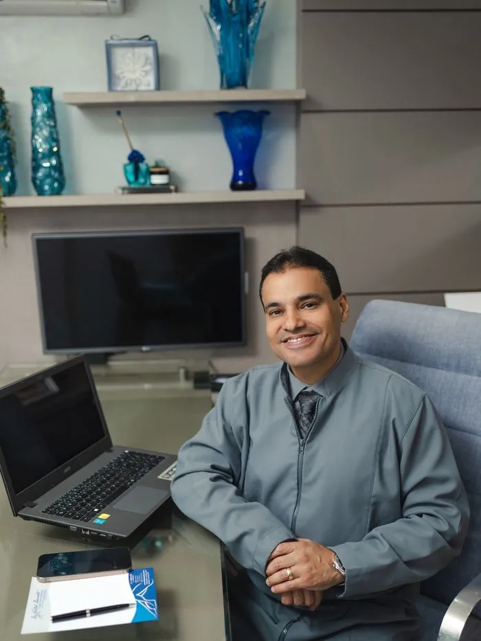 Dr. Vitor Duarte atendendo em sua mesa no consultório